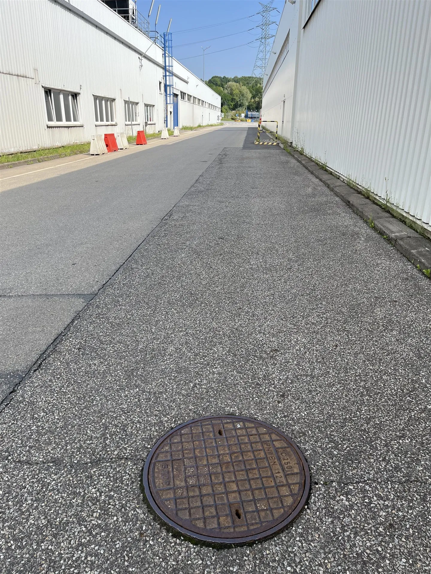 Właz studni kanalizacyjnej na drodze wewnętrznej zakładu, przed pomiarem